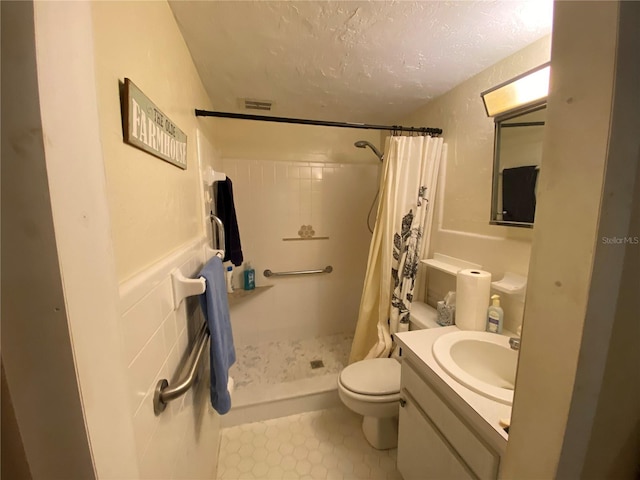 bathroom with a textured ceiling, toilet, vanity, and a shower with shower curtain