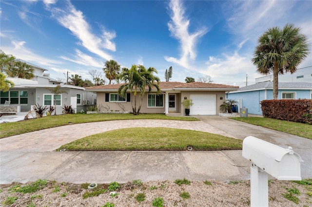 single story home featuring a garage and a front lawn