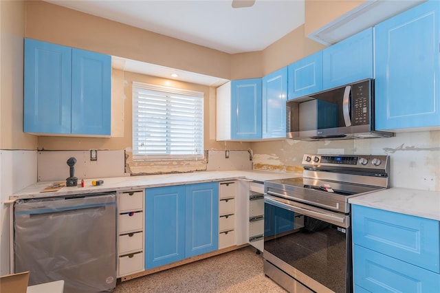 kitchen with blue cabinets, stainless steel appliances, light stone counters, and decorative backsplash