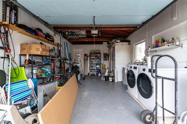 garage with separate washer and dryer and a garage door opener