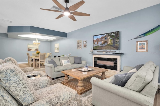 living room with wood-type flooring and ceiling fan with notable chandelier