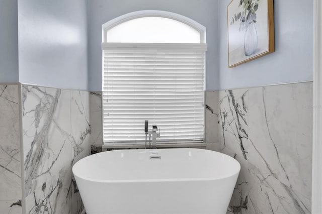 bathroom with tile walls and a bathing tub