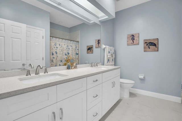 bathroom with walk in shower, vanity, toilet, and a skylight