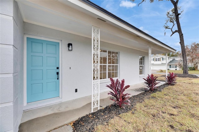 doorway to property with a lawn