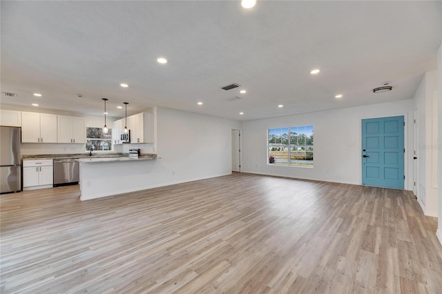 unfurnished living room with sink and light hardwood / wood-style flooring