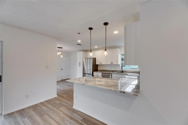 kitchen featuring kitchen peninsula, sink, white cabinets, light stone countertops, and stainless steel appliances