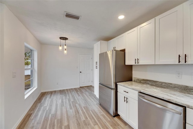 kitchen featuring decorative light fixtures, light stone countertops, white cabinetry, and stainless steel appliances