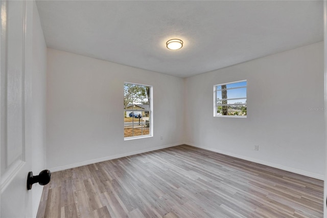 empty room with light hardwood / wood-style floors and a textured ceiling