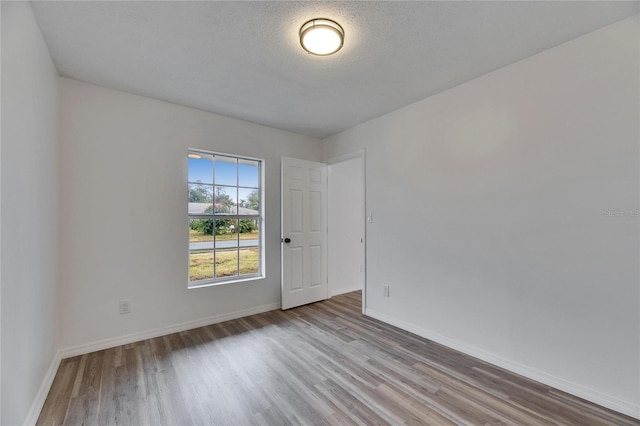 empty room featuring light hardwood / wood-style floors and a textured ceiling