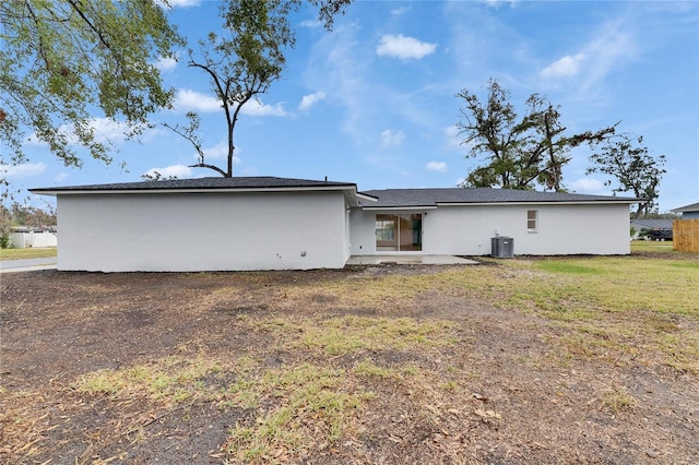 back of house with central AC unit, a lawn, and a patio