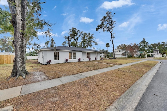 single story home featuring a front lawn