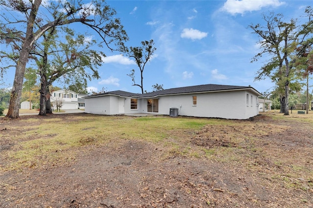 back of property with cooling unit and a yard