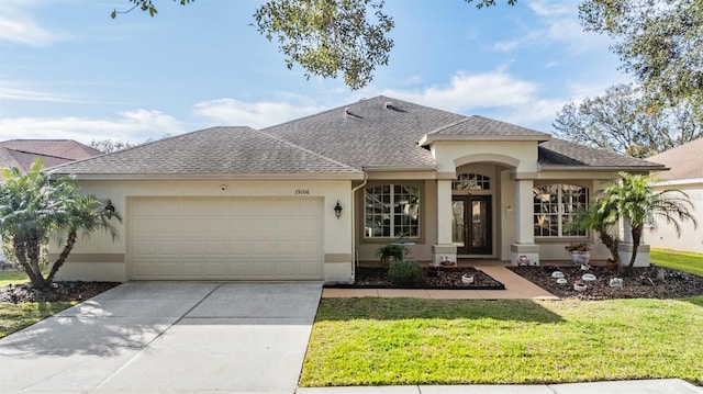 view of front of home with a garage, a front yard, and french doors