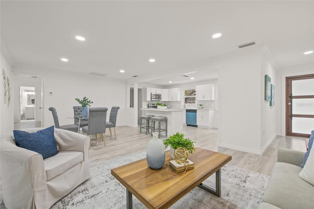 living room featuring ornamental molding and light hardwood / wood-style floors