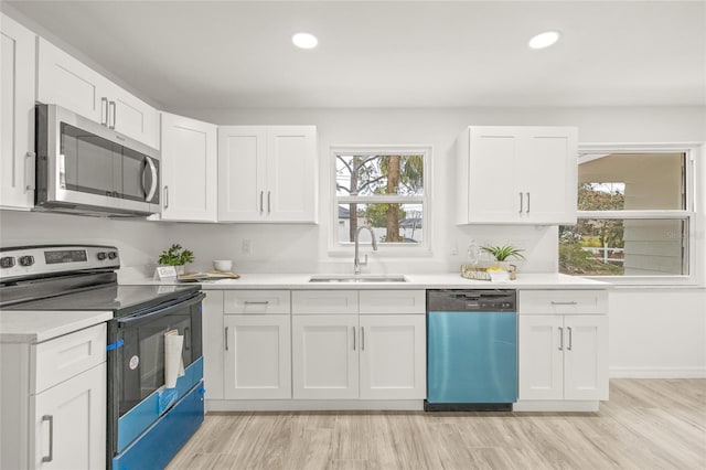 kitchen with stainless steel appliances, sink, and white cabinets