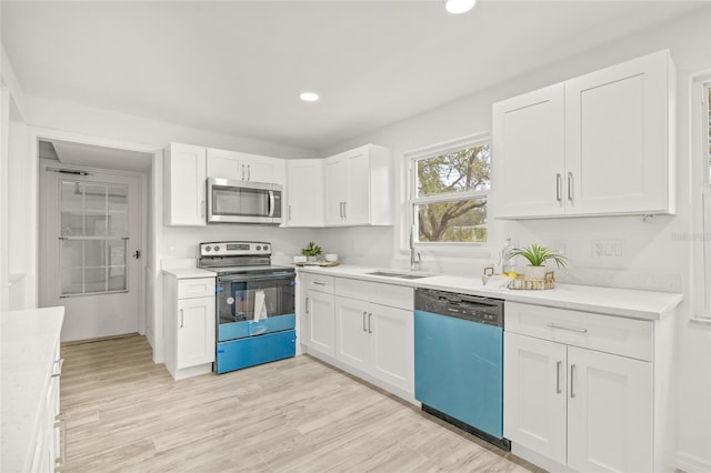 kitchen with appliances with stainless steel finishes, sink, and white cabinets