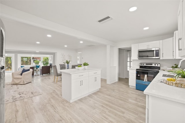 kitchen featuring white cabinetry, sink, electric range, and light hardwood / wood-style floors