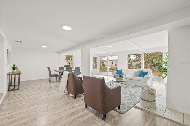 living room with beam ceiling and light wood-type flooring