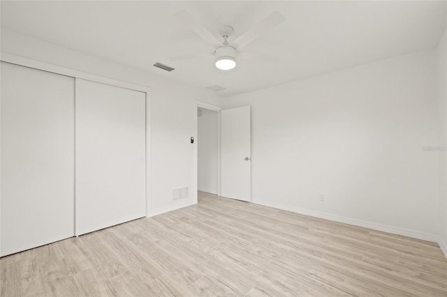 unfurnished bedroom with light hardwood / wood-style floors, a closet, and ceiling fan