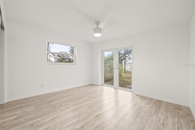 empty room with french doors, ceiling fan, and light hardwood / wood-style flooring