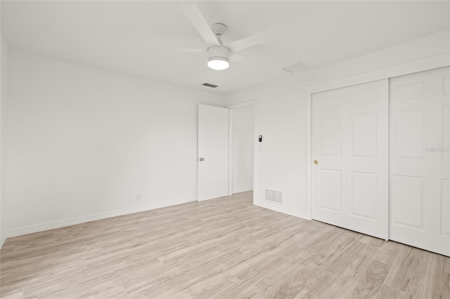 unfurnished bedroom with ceiling fan, a closet, and light hardwood / wood-style flooring