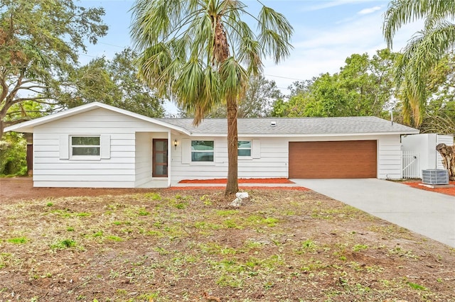 ranch-style home featuring a garage and central AC unit