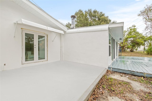 view of side of home featuring a deck and french doors