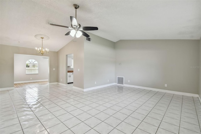 tiled empty room with lofted ceiling, ceiling fan with notable chandelier, and a textured ceiling