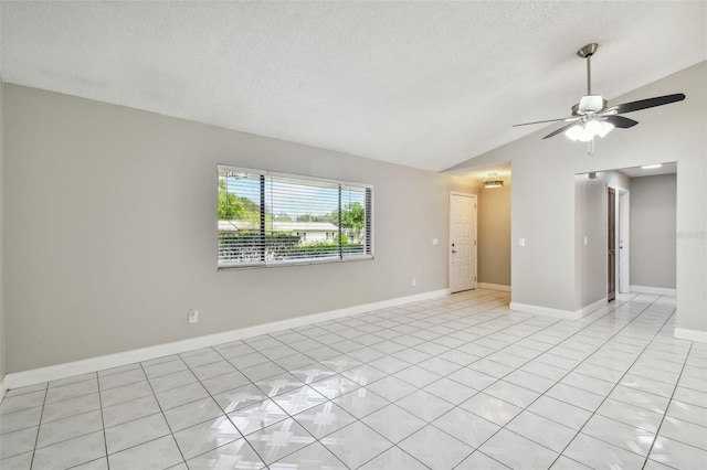 tiled empty room with ceiling fan, lofted ceiling, and a textured ceiling