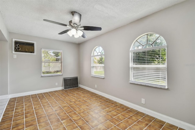 unfurnished room featuring a wall mounted AC, a textured ceiling, and ceiling fan