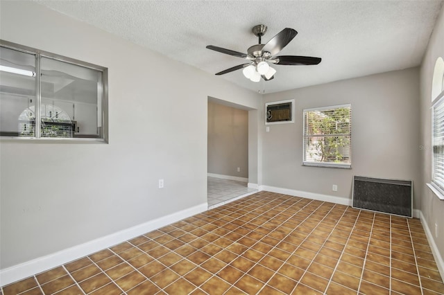 unfurnished room featuring ceiling fan, a wall mounted air conditioner, and a textured ceiling