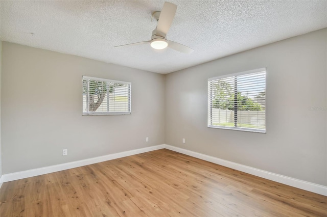 unfurnished room with a wealth of natural light, ceiling fan, and light wood-type flooring