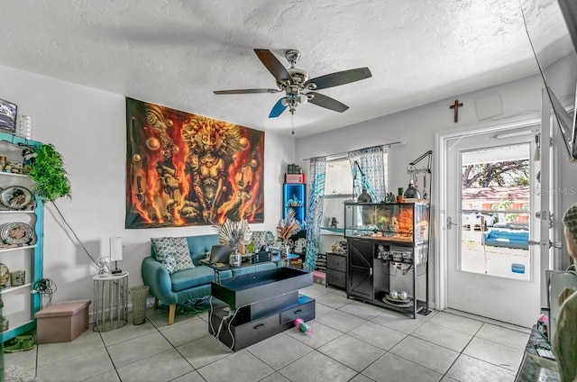 sitting room featuring a textured ceiling, light tile patterned floors, and ceiling fan