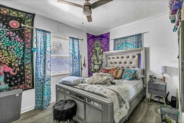 bedroom with ceiling fan, hardwood / wood-style floors, and a textured ceiling