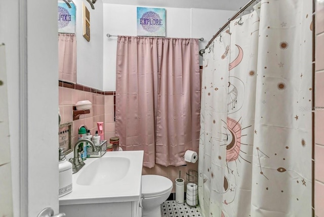 bathroom featuring a shower with curtain, toilet, vanity, and tile walls