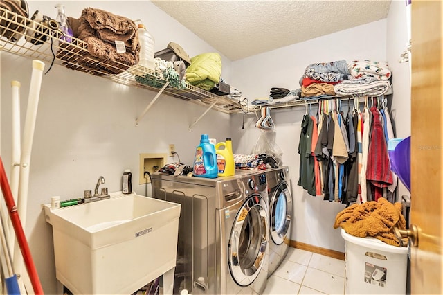 washroom featuring sink, independent washer and dryer, a textured ceiling, and light tile patterned floors