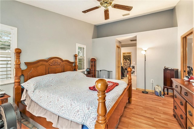 bedroom with multiple windows, a spacious closet, ceiling fan, and light hardwood / wood-style floors