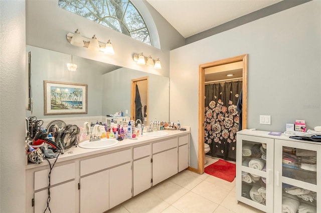 bathroom featuring vanity, toilet, tile patterned floors, and lofted ceiling