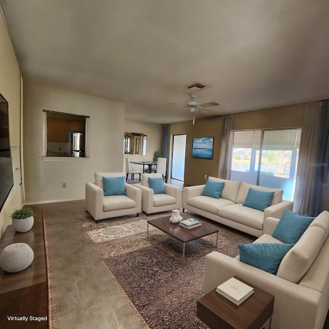 living area featuring a ceiling fan and visible vents