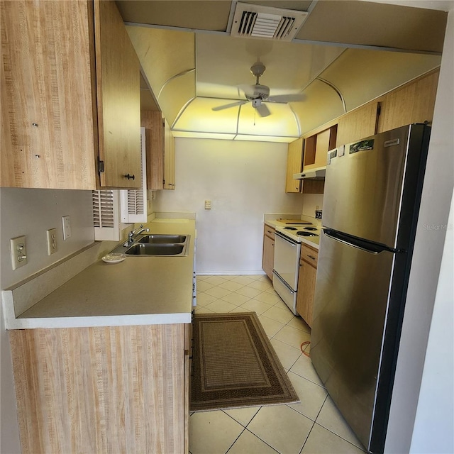 kitchen featuring light tile patterned floors, visible vents, white range with electric cooktop, freestanding refrigerator, and a sink