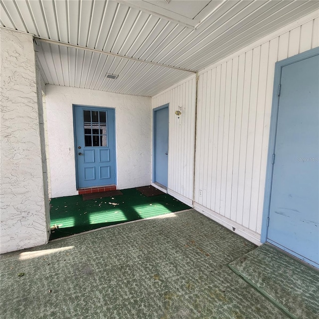 doorway to property featuring stucco siding