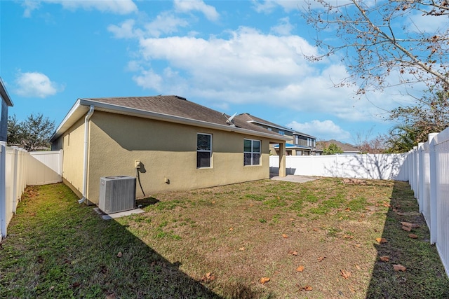 back of property with a yard and central air condition unit