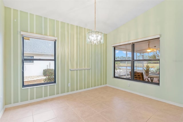 tiled empty room with an inviting chandelier