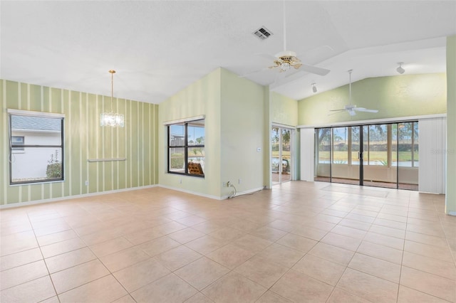 tiled empty room with ceiling fan with notable chandelier and lofted ceiling