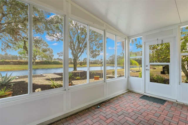 unfurnished sunroom featuring a water view