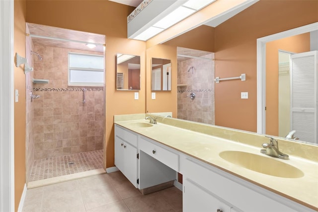 bathroom with vanity, tiled shower, and tile patterned flooring