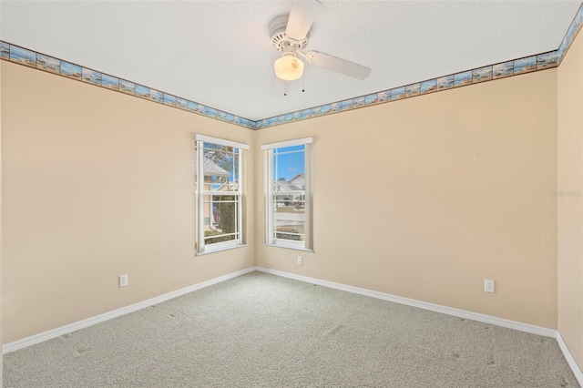 carpeted spare room featuring ceiling fan