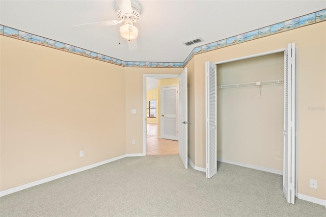 unfurnished bedroom featuring light colored carpet, a closet, and ceiling fan