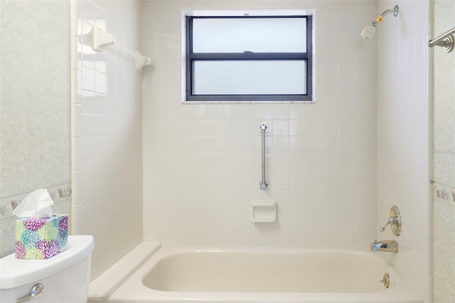 bathroom with toilet and tiled shower / bath combo