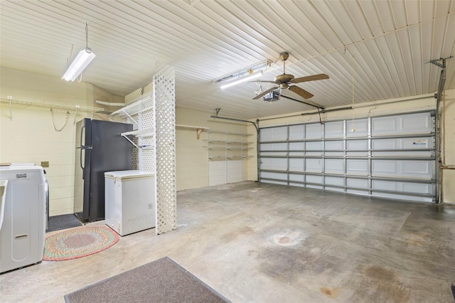 garage featuring black refrigerator, refrigerator, washer / clothes dryer, and a garage door opener